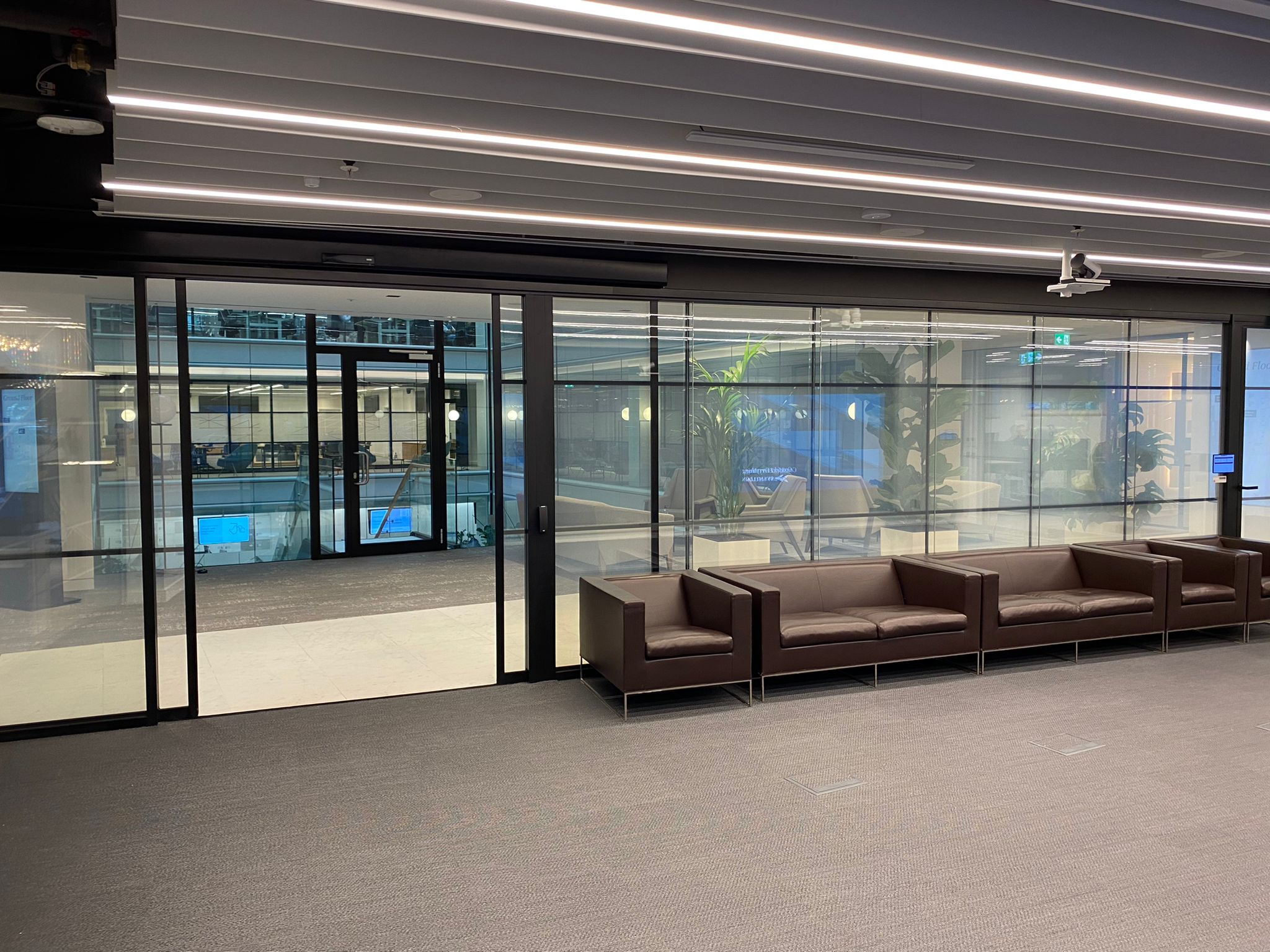 Open welcome area with smart glass wall and sliding door entry