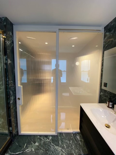 Switchable glass in sliding doors offer flexible privacy and natural light.