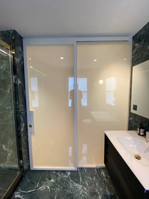Sliding bathroom doors offer flexible privacy and natural light in a residential bathroom.